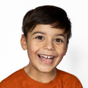 Modern School Photo of excited boy in orange shirt and white background